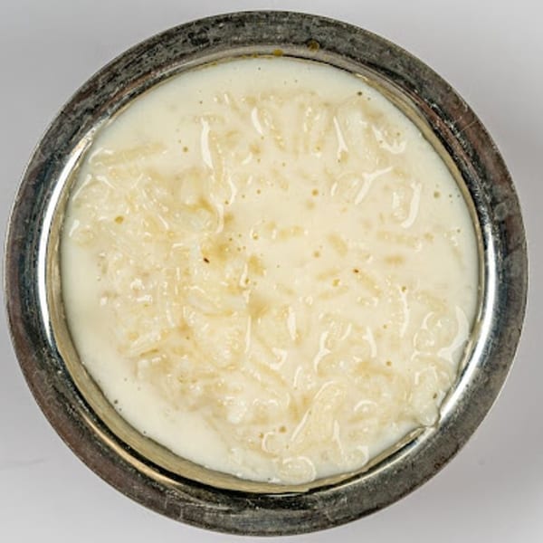 Creamy Indian rice pudding, Kheer, in a silver bowl, viewed from above.
